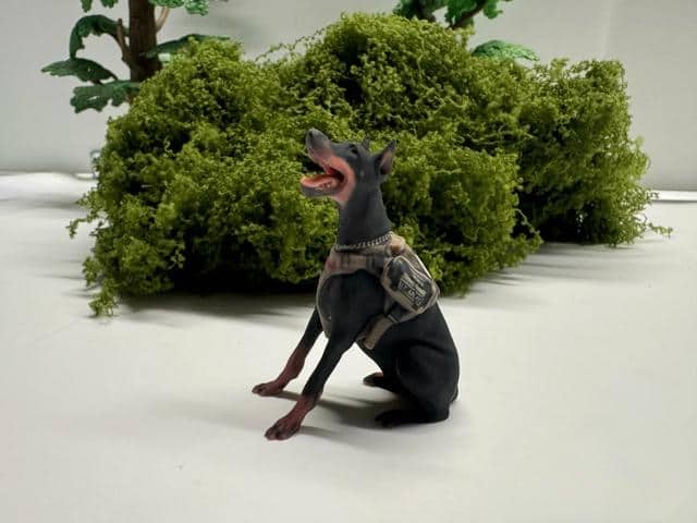 A finished Doberman figurine with its collar and harness captured in color