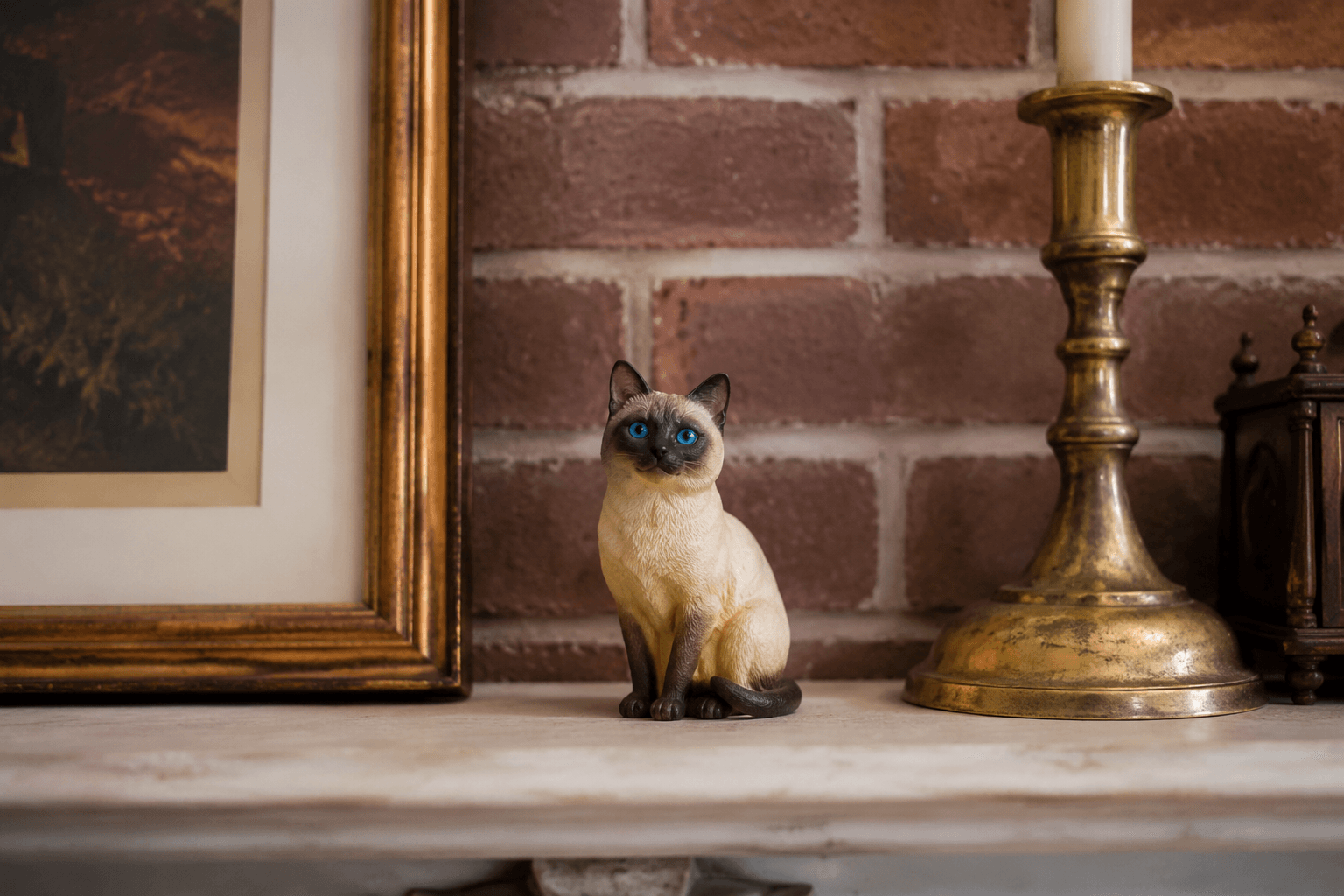 Siamese cat figurine sitting upright with blue eyes and point coloring