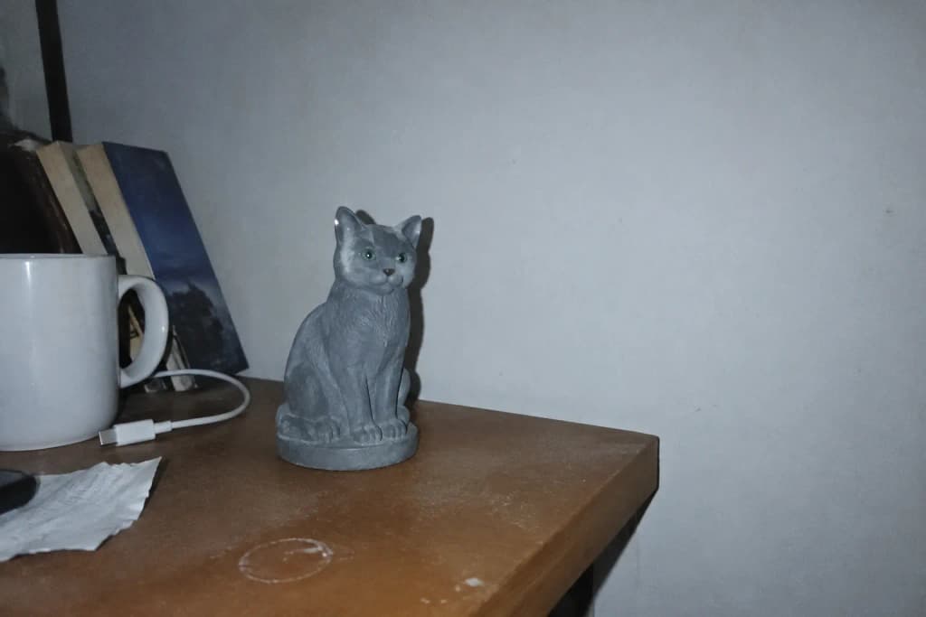 Full-color resin figurine of a Russian Blue cat sitting poised and calm — in-article view