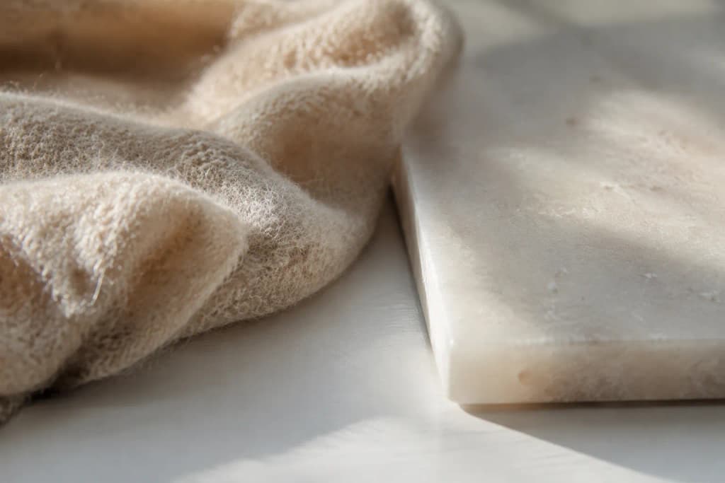 Close-up of two contrasting material textures side by side on a white surface highlighted by natural window light
